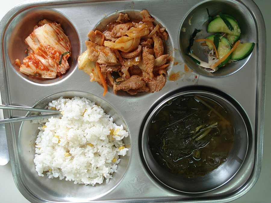 Suất cơm trên khay inox chia ngăn: cơm, canh, món mặn, rau